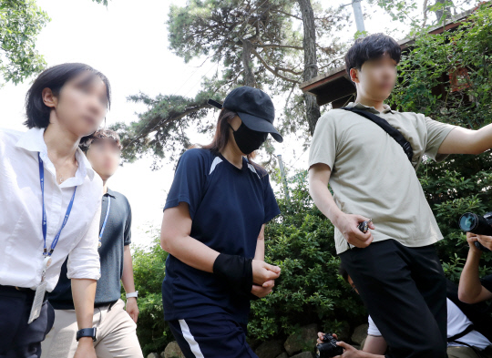 6일 오후 경기 김포시 대곶면 한 텃밭 입구에서 태어난 지 하루 된 딸을 암매장한 혐의를 받는 40대 여성이 현장 검증을 마치고 이동하고 있다. [김포=연합뉴스]
